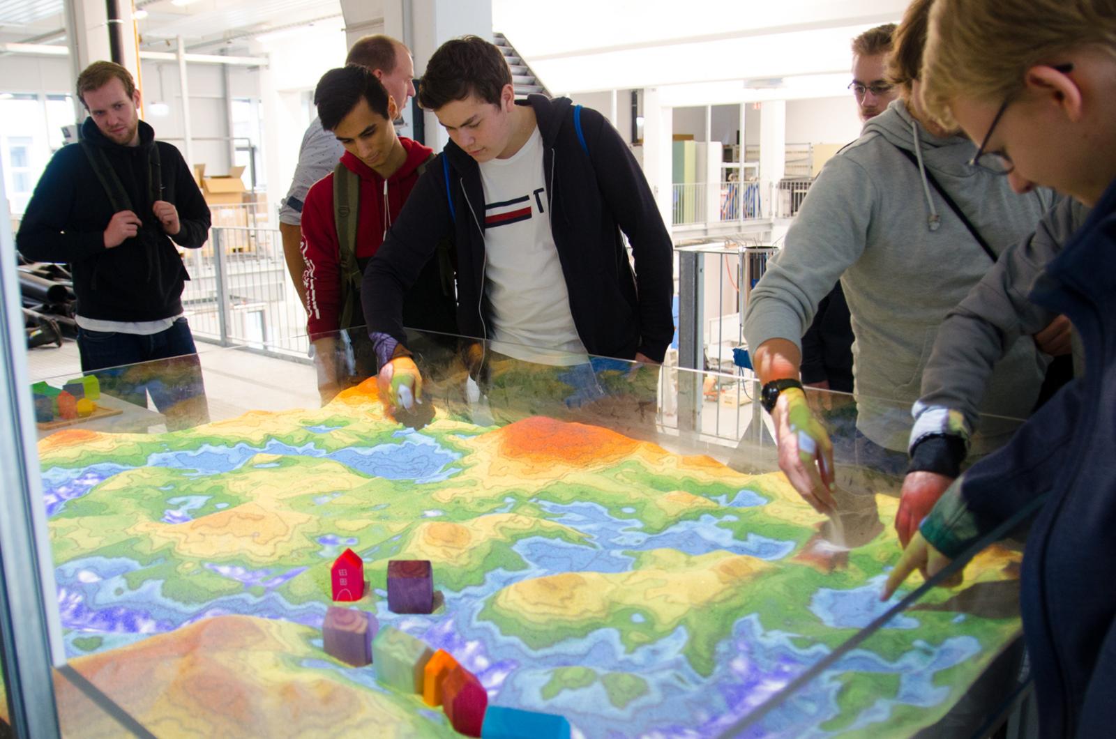 An der Augmented-Reality-Sandbox konnten die Schüler Gelände modellieren, es imaginär regnen lassen – und dann beobachten, wie sich das Wasser verteilt. (Foto: FH Münster/Theresa Gerks)
